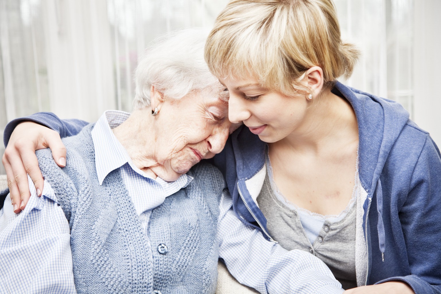home caregiver consoling sad senior woman